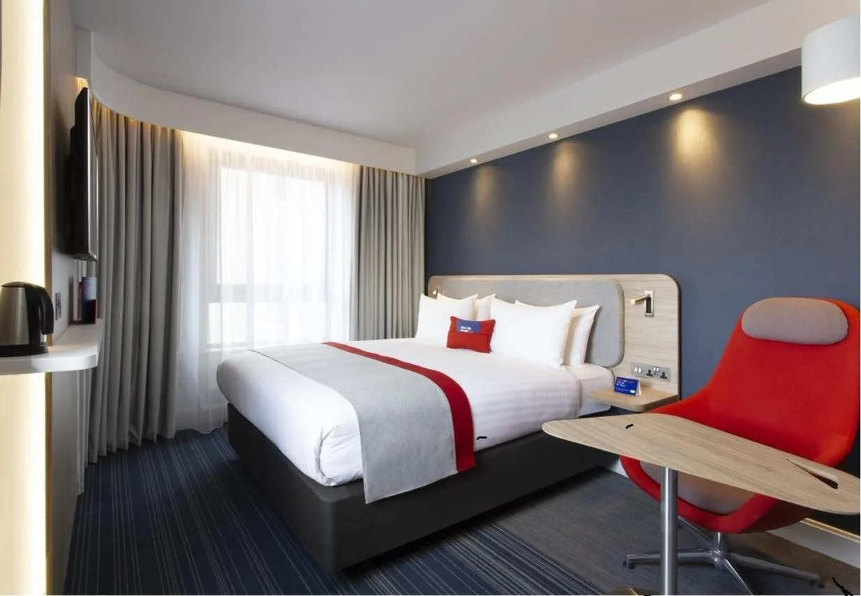 Hotel room with bed and red chair at Holiday Inn Express Edinburgh City Centre