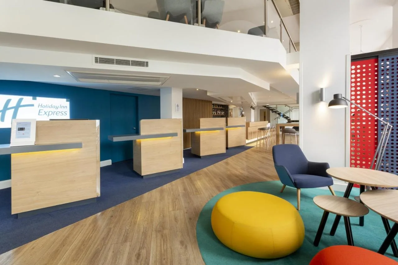 Bright office space with desks and a yellow stool